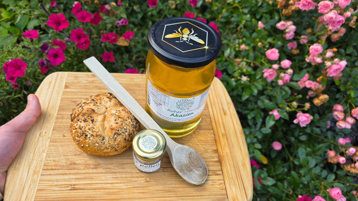 Glas Akazienhonig mit Brötchen und Holzlöffel